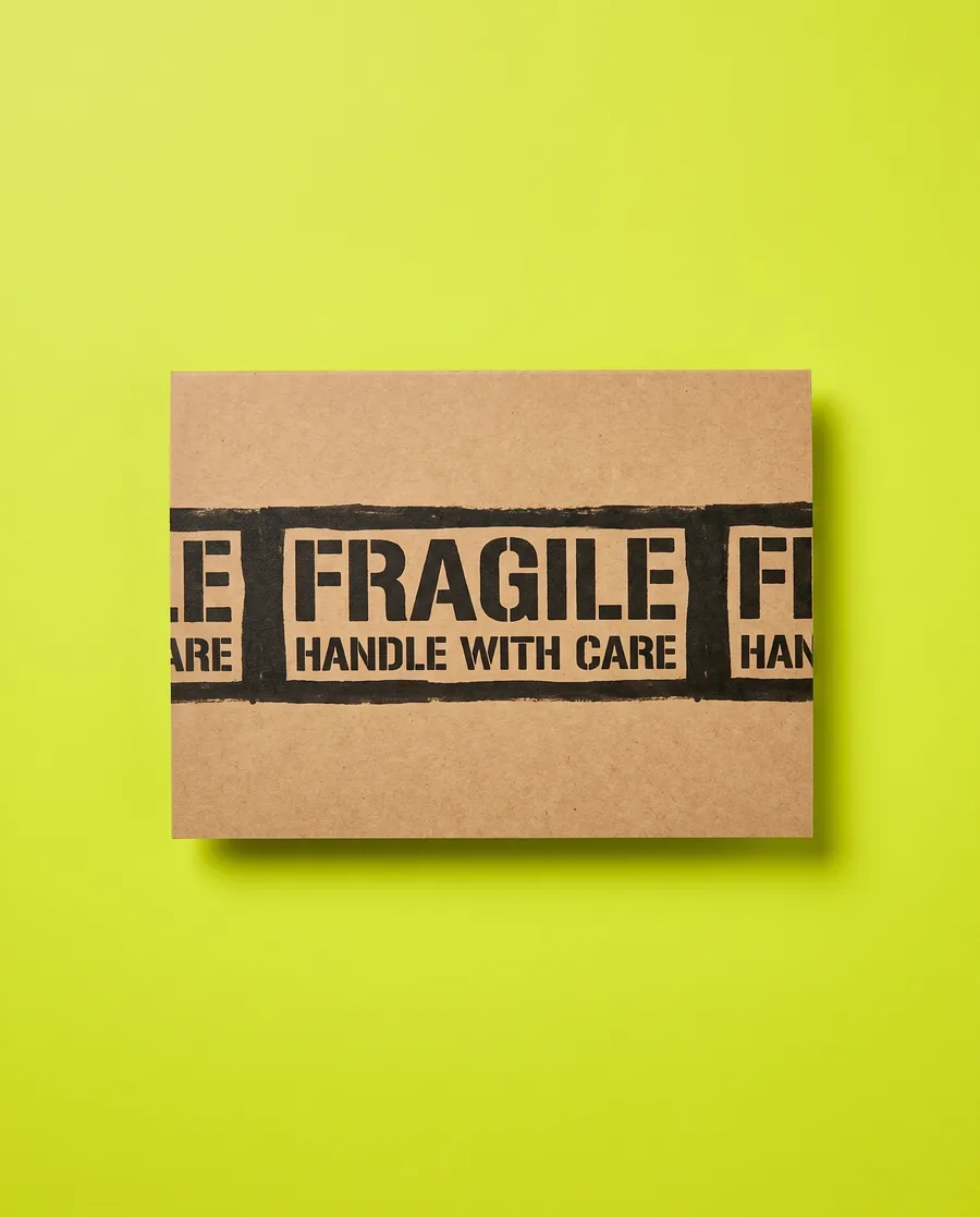 Kraft proof card on acid green: FRAGILE over HANDLE WITH CARE, an inverted 30 mm shipping band, printed with a Rolly 3.0